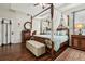 Main bedroom with canopy bed, hardwood floors, and access to the bathroom at 648 Cortona Dr, Orlando, FL 32828