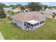 An aerial view showcasing a house's backyard, screened porch, and landscaping at 707 Terranova Ave, Winter Haven, FL 33884