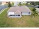 Aerial view of the home with an enclosed lanai, lush lawn, and a well-maintained landscape at 707 Terranova Ave, Winter Haven, FL 33884