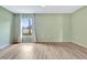 Spacious bedroom filled with light from the large window, complemented by neutral walls and wood-look floors at 707 Terranova Ave, Winter Haven, FL 33884