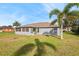 Back of house with screened porch and lush green lawn at 707 Terranova Ave, Winter Haven, FL 33884