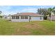 Rear view of house featuring a screened porch and green lawn at 707 Terranova Ave, Winter Haven, FL 33884