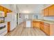 Open kitchen boasts wood cabinets, modern appliances, and a pass-through breakfast bar for easy entertaining at 707 Terranova Ave, Winter Haven, FL 33884