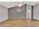 Neutral living room featuring vaulted ceilings, wood-look flooring, and a ceiling fan at 707 Terranova Ave, Winter Haven, FL 33884