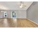 Spacious living room with wood-look floors, a ceiling fan, and sliding door to a screened lanai at 707 Terranova Ave, Winter Haven, FL 33884