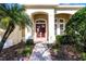 Front entry with double red doors, brick walkway and landscaping at 8231 Lynch Dr, Orlando, FL 32835