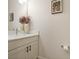 Modern powder room with a white vanity, quartz countertop, and stylish decor at 8575 Hempstead Way, Mount Dora, FL 32757