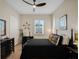 Bright bedroom with a black bed frame, dresser, and window with shutters at 8575 Hempstead Way, Mount Dora, FL 32757