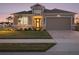 Two-story house exterior at dusk, with landscaping and a three-car garage at 8575 Hempstead Way, Mount Dora, FL 32757