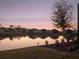 Scenic lake view with reflection of houses at sunset at 8575 Hempstead Way, Mount Dora, FL 32757