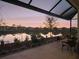 Serene patio view at sunset, overlooking a peaceful lake at 8575 Hempstead Way, Mount Dora, FL 32757