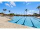 Community swimming pool with lap lanes is surrounded by lush landscaping and palm trees at 8575 Hempstead Way, Mount Dora, FL 32757