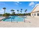 A resort-style swimming pool with palm trees and brick patio offers a luxurious experience at 8575 Hempstead Way, Mount Dora, FL 32757