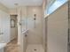 Walk-in shower with glass enclosure and neutral tile at 8575 Hempstead Way, Mount Dora, FL 32757