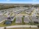 Aerial view showcasing a neighborhood with houses, roads, and a lake in the distance at 9653 Early Loop, Groveland, FL 34736