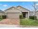 Tan one story house with brick driveway and landscaping at 9653 Early Loop, Groveland, FL 34736