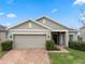 Tan one-story house with brick driveway and landscaping at 9653 Early Loop, Groveland, FL 34736