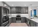 Modern kitchen with gray cabinets, stainless steel appliances, and white quartz countertops at 9653 Early Loop, Groveland, FL 34736