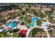 Aerial view of community pool, lush landscaping, and surrounding buildings at 100 Napoli Dr, Davenport, FL 33897