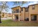 Back exterior view of the house with balcony and patio at 100 Napoli Dr, Davenport, FL 33897