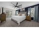 Spacious main bedroom with king-size bed, balcony access, and ceiling fan at 100 Napoli Dr, Davenport, FL 33897