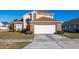 Two-story house with brick facade, attached garage, and well-manicured lawn at 108 Strait Dr, Davenport, FL 33897