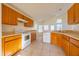 Kitchen with wood cabinets, white appliances, and tile flooring at 108 Strait Dr, Davenport, FL 33897