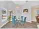 Modern dining room with glass table, four chairs, and artwork at 11016 Orangeshire Ct, Ocoee, FL 34761