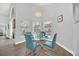 Bright dining room features a glass table and four teal chairs at 11016 Orangeshire Ct, Ocoee, FL 34761