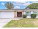 House exterior featuring a white garage door and brick accents at 116 Sheridan Ave, Longwood, FL 32750