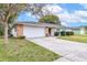 Inviting exterior of a single-Gathering home with a garage, manicured lawn, and blue shutters on the windows at 116 Sheridan Ave, Longwood, FL 32750