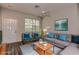 Virtually staged living room with gray sofa, teal accent pillows, and wood coffee table at 12557 Langstaff Dr, Windermere, FL 34786