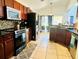 Kitchen with dark wood cabinets, granite countertops and black appliances at 1708 Clubhouse Cv, Haines City, FL 33844