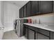 Well-equipped laundry room with washer, dryer, and dark cabinets at 1713 Fullers Oak Loop, Winter Garden, FL 34787