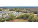 Aerial view showing houses, a road, and surrounding trees at 1870 Dumbleton Pl, St Cloud, FL 34771