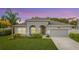 Single-story house with gray siding, arched entryway, and two-car garage at 1870 Dumbleton Pl, St Cloud, FL 34771