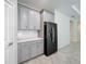 Gray kitchen cabinets, quartz countertops and a black refrigerator at 1870 Dumbleton Pl, St Cloud, FL 34771