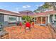 Brick patio with red chairs and umbrella near the home entrance at 1871 Linden Rd, Winter Park, FL 32792