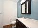 Bathroom with dark vanity, white countertop, and mirrored medicine cabinet at 2090 Ashland Blvd, Orlando, FL 32808