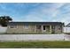 Ranch style home with a yellow brick exterior, dark roof, and a low concrete wall in the front yard at 2090 Ashland Blvd, Orlando, FL 32808