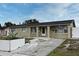 Light yellow brick ranch home with a dark roof and a concrete driveway at 2090 Ashland Blvd, Orlando, FL 32808