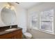 Simple bathroom with granite vanity, oval mirror, and white toilet at 2409 Kilgore St, Orlando, FL 32803