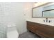 Bathroom with white subway tile, wood vanity, and patterned floor at 2580 Grassy Point Dr # 102, Lake Mary, FL 32746