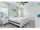 Bright bedroom featuring a ceiling fan, a large bed, a nightstand, and light-colored flooring at 2904 On The Rocks Pt, Kissimmee, FL 34747