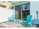 Small patio with two teal chairs and a side table at 2904 On The Rocks Pt, Kissimmee, FL 34747