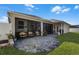 Paver patio in backyard with screened lanai with seating and lush landscaping at 381 Skyview Pl, Chuluota, FL 32766