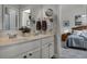 Bright bathroom featuring a double sink vanity with marble countertop and views to the primary bedroom at 381 Skyview Pl, Chuluota, FL 32766