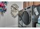 Modern laundry room with stainless steel front-loading washer and dryer, and decorative dream catcher at 381 Skyview Pl, Chuluota, FL 32766