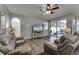 Bright living room featuring sliding doors to the patio, comfortable seating, and a large TV at 381 Skyview Pl, Chuluota, FL 32766