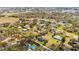 Aerial view of a property with a blue two-story home amid lush greenery in a neighborhood at 3943 W Campbell Rd, Lakeland, FL 33810